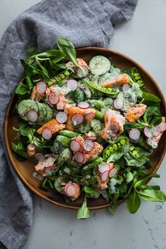 a salad with radishes and spinach in a bowl