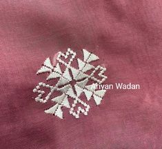 an embroidered snowflake is shown on a pink fabric with white stitching in the center