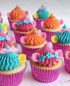 cupcakes decorated with colorful frosting and bows