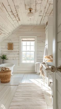 a bathroom with white walls and wood flooring, along with a rug on the floor