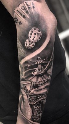 a man's arm with dices and gambling cards on the back of his arm