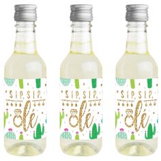 three bottles of water with gold lettering and cactus designs on them, one is empty