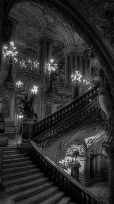 an old building with stairs and chandeliers in the center is featured on this black - and - white photo