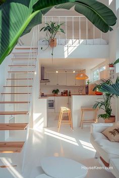 a living room filled with furniture next to a kitchen and dining area under a stair case