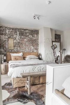 a bedroom with brick walls and white furniture