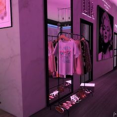 there is a purple room with shoes and t - shirts on the rack in front of it