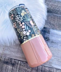 a pink tumbler sitting on top of a white furnishing next to a wooden floor