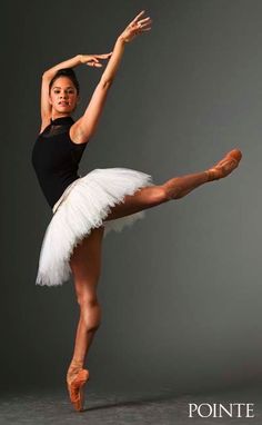 a young ballerina is posing for the camera