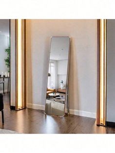 a large mirror sitting on top of a wooden floor