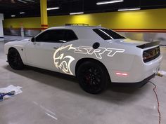 a white car parked in a garage with the word sport on it's side