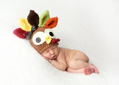 a newborn baby wearing a crocheted turkey hat