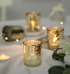 lit candles on a table with flowers and napkins