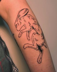 a person with a tattoo on their arm that has a drawing of a rabbit on it