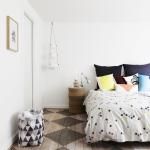 a bed sitting in a bedroom on top of a checkered floor