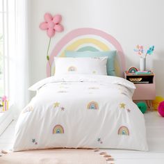 a white bed with rainbows and stars on it