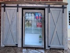 an open refrigerator door on the side of a brick building with glass doors and sliding doors