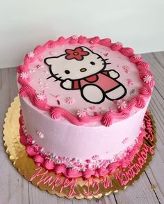 a hello kitty birthday cake with pink frosting and sprinkles on top