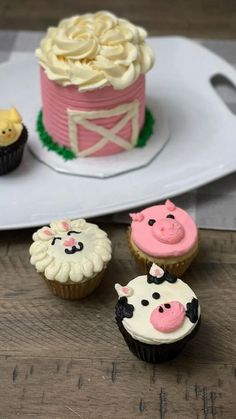 three cupcakes with frosting and farm animals on them are sitting next to each other