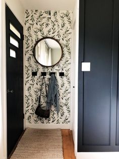 a hallway with a mirror, coat rack and rug