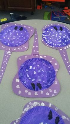 purple paper plates with black dots and hearts on them sitting on a table in the middle of a room