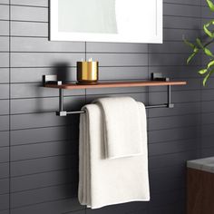 a towel rack with two towels hanging on it next to a mirror and sink in a bathroom