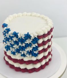 an american flag cake with white frosting and red, white, and blue decorations