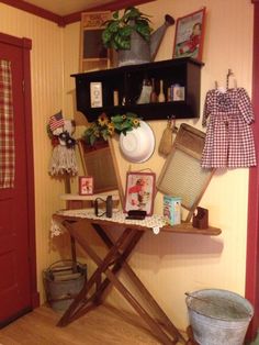 a table with pictures and other items on it in a room next to a red door