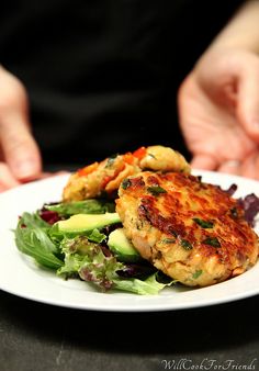 two crab cakes on a white plate with lettuce