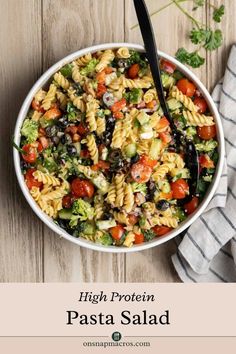 pasta salad with tomatoes, broccoli and black olives in a white bowl