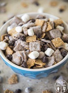 a blue bowl filled with cereal and marshmallows