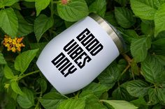 a white coffee mug with the words good times on it sitting in some green leaves