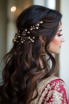 a woman with long dark hair wearing a gold headpiece and earrings on her head