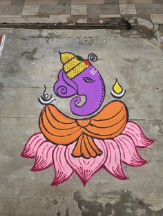 an elephant painted on the side of a building with a flower in front of it