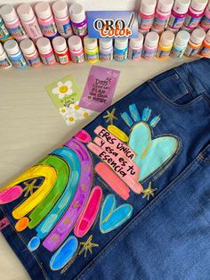 a pair of blue jean shorts sitting on top of a table next to markers and pens