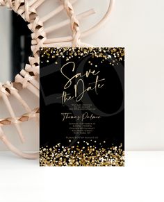 black and gold wedding save the date card with confetti on it in front of a white background