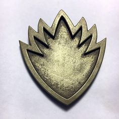 a metal badge with an arrow on it's side and two smaller arrows in the middle