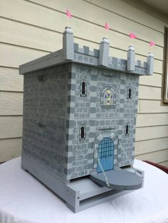 a castle made out of cardboard sitting on top of a white cloth covered tablecloth