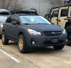 a subarunt is parked in the parking lot next to two suv's