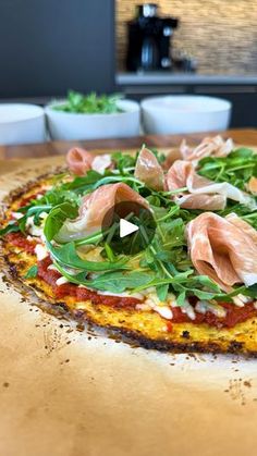 a pizza topped with meat and veggies on top of a wooden cutting board