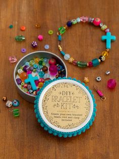 a wooden table topped with a metal container filled with lots of beads