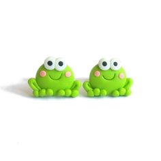 two green toy frogs sitting next to each other