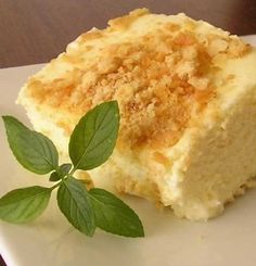 a piece of cake sitting on top of a white plate next to a green leaf