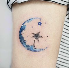 a small palm tree and moon tattoo on the thigh