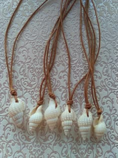 four seashells are hanging from a cord