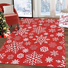 a red rug with white snowflakes on it in front of a christmas tree