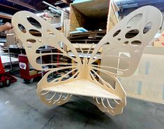 a large wooden butterfly sitting on top of a piece of furniture in a room filled with boxes