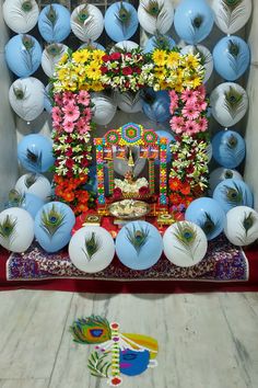 a decorated stage with peacocks and flowers on the wall, surrounded by other decorations