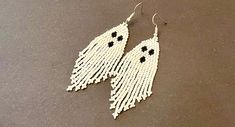 white beaded earrings with black beads hanging from them