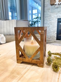 a candle sits on a table next to some flowers