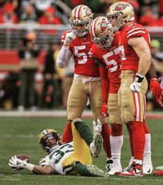 three football players are huddled together on the field